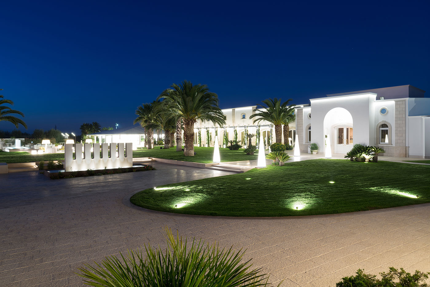 Corte Martinelli separates palms, lawn and the white architecture beyond.